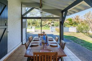 a wooden table and chairs on a patio at Villa Blue Pool - Welkeys in Seignosse