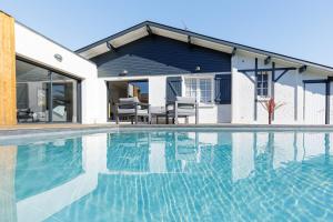 a house with a swimming pool in front of a house at Villa Blue Pool - Welkeys in Seignosse +14 photos