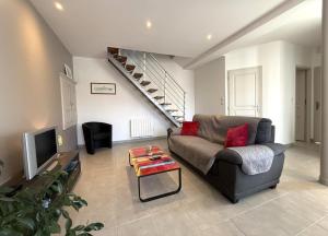 a living room with a couch and a tv at Anetania in Saint-Palais