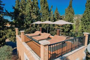 a patio with two chairs and an umbrella at S'Hort de Son Caulelles - Adults Only in Marratxí 