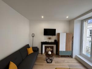 a living room with a couch and a fireplace at Le Cocon Maison Reve Excellence in Écommoy