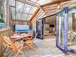 a conservatory with a table and chairs on a deck at 2 Bed in Truro oc-93315 in Porthtowan