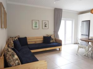 a living room with a blue couch and a table at Waterland Lodge in Hout Bay