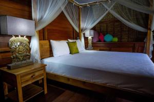 ein Schlafzimmer mit einem großen Bett mit Baldachin in der Unterkunft Alam Taman Villa in Tabanan