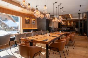 a dining room with a long table and chairs at RESORT JEZERNÍ Apartmány & Penzion Wellness in Železná Ruda