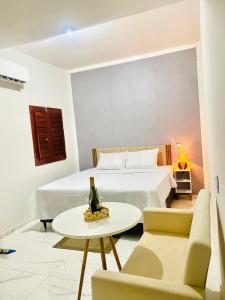 a bedroom with a bed and a table with a bottle of champagne at Apart hotel Refúgio tropical Icarai de amontada in Amontada +18 photos