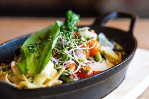 a black pan filled with pasta and vegetables at Köhlerei am See in Feldberg +55 photos