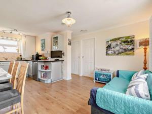 a living room with a couch and a kitchen at 2 Bed in Helston oc-54556 in Mullion +12 photos