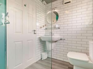 a bathroom with a toilet and a sink and a mirror at 2 Bed in Helston oc-54556 in Mullion