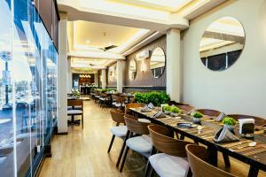 a restaurant with wooden tables and chairs and a large window at Esplendor by Wyndham Los Mochis Country Place in Los Mochis