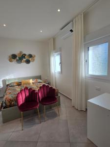 a bedroom with a bed and two red chairs at Appartamento Teodorico Ravenna in Ravenna