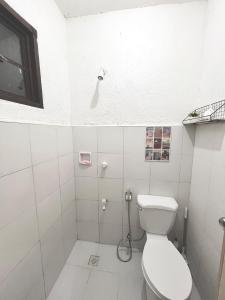 a white bathroom with a toilet and a shower at Casa Ezeah Tagum Staycation in Tagum +23 photos