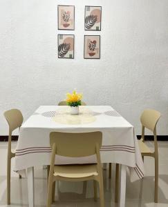 a dining room table with chairs and a vase with flowers at Casa Ezeah Tagum Staycation in Tagum