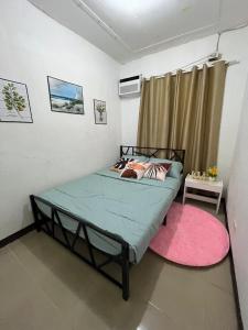 a bedroom with a bed and a pink rug at Casa Ezeah Tagum Staycation in Tagum