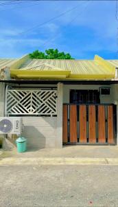 a building with wooden doors and a yellow roof at Casa Ezeah Tagum Staycation in Tagum