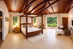 a bedroom with a canopy bed in a room at Cinnamon Room Four-Poster Bed, Freestanding Bath, Walk-In Shower & Infinity Pool in Cap Malheureux