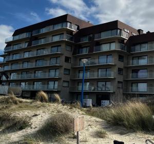a building on the beach next to the sand at Villa Castelli 52 Groenendijk in Nieuwpoort