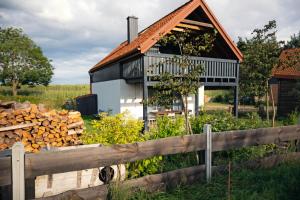 a house with a pile of wood in front of it at Smugi Dom Gościnny in Lipowiec