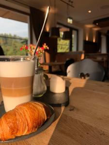 a cup of coffee and a loaf of bread on a table at Köhlerei am See in Feldberg