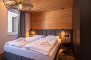 a bedroom with a large bed with white sheets at RESORT JEZERNÍ Apartmány & Penzion Wellness in Železná Ruda +106 photos