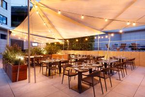 a restaurant with tables and chairs under a tent at Hotel SB Icaria in Barcelona