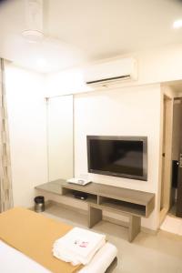 a living room with a television on a table at Hotel Maharaja in Thane