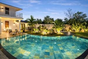 a swimming pool in the backyard of a house at Cinnamon Room Four-Poster Bed, Freestanding Bath, Walk-In Shower & Infinity Pool in Cap Malheureux