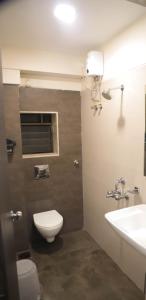 a bathroom with a toilet and a sink at Hotel Maharaja in Thane