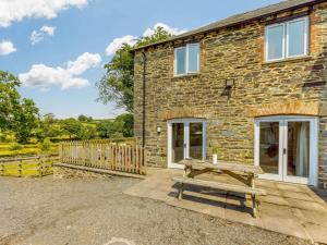a stone house with a picnic bench in front of it at 3 Bed in Launceston oc-88858 in Saint Giles on the Heath