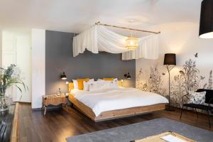 a bedroom with a large white bed with yellow pillows at Posthotel Alexander Herrmann in Wirsberg