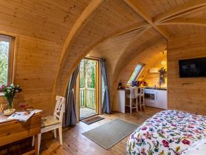 a bedroom in a log cabin with a bed and a desk at 1 Bed in Padstow oc-77748 in Padstow