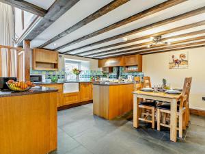 a large kitchen with wooden cabinets and a table at 2 Bed in Launceston oc-92551 in Saint Giles on the Heath