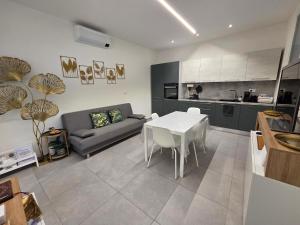 a kitchen and living room with a table and a couch at Appartamento Teodorico Ravenna in Ravenna