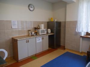 a small kitchen with a microwave and a refrigerator at Hotel Sowa in Częstochowa