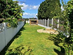a fence with a yard with a bus in the background at Superbe maison 85m2 - Plages à 2km - Jardin clos - Maison Kaerell in Billiers +31 photos