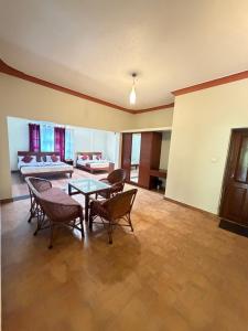 a living room with a table and chairs and a couch at Deva Maani Coorg Nature View in Madikeri