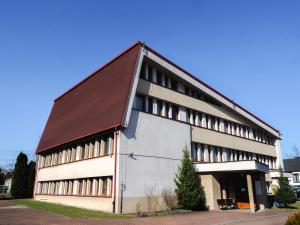 a large white building with a brown roof at Hotel Sowa in Częstochowa