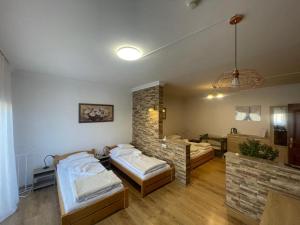 a room with two beds and a brick wall at Euro Accommodation in Debrecen