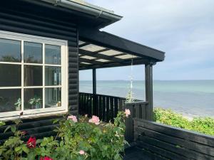 a house with a window and a view of the ocean at Breathtaking Sea View At Dinestrup Beach in Ullerslev