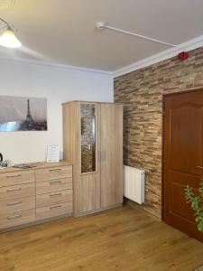 a room with a wooden cabinet and a brick wall at Euro Accommodation in Debrecen