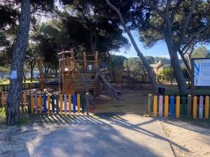 a playground with a slide in a park with trees at Caparica Sol&Mar Apartment in Costa da Caparica