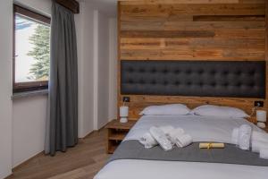 a bedroom with a large bed with white pillows at Hotel Gran Roc in Sestriere