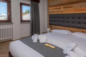 a bedroom with a large white bed with a cross on it at Hotel Gran Roc in Sestriere +25 photos