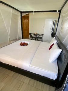 a large bed in a tent with a table at Amara Kivu Resort in Île Bugarura +7 photos
