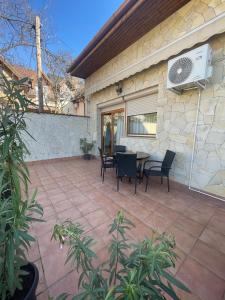 a patio with chairs and a table and a fan at Euro Accommodation in Debrecen