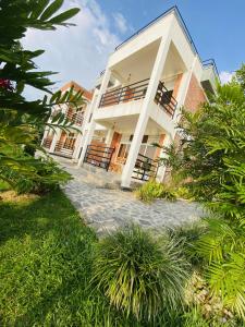 a white building with a walkway in front of it at Amara Kivu Resort in Île Bugarura