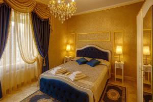 a bedroom with a blue bed and a chandelier at Il Castello Di Venere in Rota d'Imagna