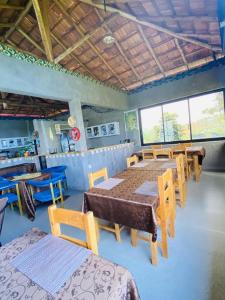 a dining room with tables and chairs and windows at Amara Kivu Resort in Île Bugarura
