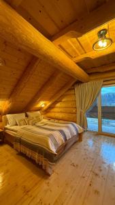 a bedroom with a large bed in a wooden ceiling at Derevo House in Yasinya