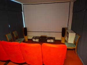 a room with red chairs and a large screen at Villa Sysslebäck Branäs Långberget in Sysslebäck